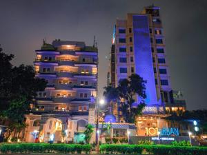 a large building with blue lights on it at night at 1O1 URBAN Jakarta Thamrin in Jakarta