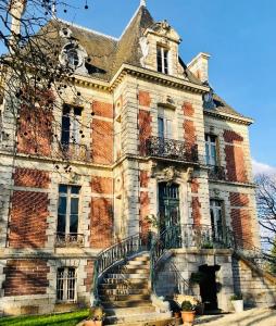 stary ceglany budynek ze schodami przed nim w obiekcie Suite privée bleu au château de la Franceule w mieście Janzé