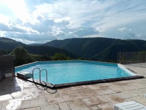 a swimming pool with mountains in the background at Gites de la Bastide, 30750 Trèves in Tréves