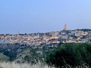 a city on top of a mountain at night at La Suite Matera Hotel & Spa in Matera