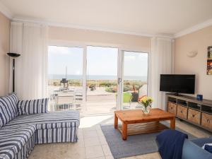 a living room with a couch and a tv at 7 Min Y Traeth in Pwllheli