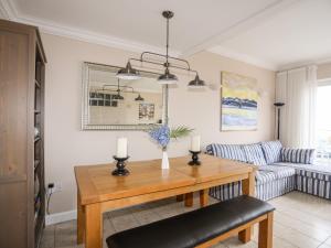 ein Wohnzimmer mit einem Tisch und einem Sofa in der Unterkunft 7 Min Y Traeth in Pwllheli
