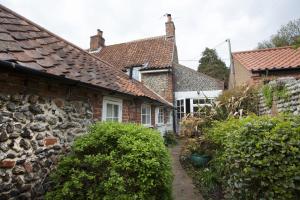 a row of cottages in the village of welford on harcourt at Honey Barrel Cottage in Stiffkey