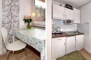 a small kitchen with a table and a vase of flowers at Terrassenhaus, FeWo 22 in Duhnen