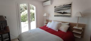 Un dormitorio con una cama grande con almohadas rojas y blancas. en Les Hauts de Carcès, en Carcès