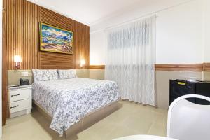 a small bedroom with a bed and a window at Hotel La Casona Dorada in Santo Domingo