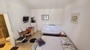 ein kleines Zimmer mit einem Bett und einer Couch darin in der Unterkunft Apartment house Berry in Primošten