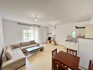 uma sala de estar com um sofá e uma mesa em Gregor Apartments 1 em Saranda
