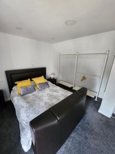 a bedroom with a bed and a leather couch at Woodborough road close to city in Nottingham