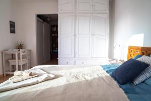 een slaapkamer met een groot wit bed met blauwe kussens bij Casa Harmonia in La Pared