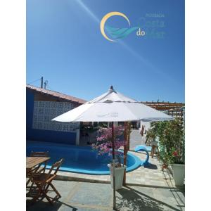 Villa con piscina y sombrilla en Pousada Costa do Mar, en Luís Correia