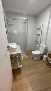 a bathroom with a toilet and a glass shower at Vivienda Vista Mayor 3 dorm íntegro in La Guardia