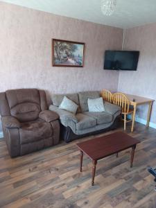 a living room with a couch and a table at Hill view Cottage in Curr