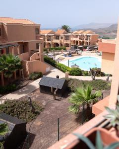 een balkon met uitzicht op het zwembad van een resort bij Casa Harmonia in La Pared