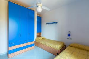 - une chambre avec 2 lits et une armoire bleue dans l'établissement Friendly&Family Apartment at Ischia, à Ischia