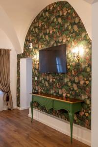 un soggiorno con pianoforte verde contro una parete floreale di Sia Boutique Aparthotel a Sibiu