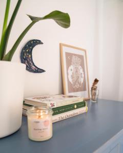 una pila di libri appoggiata su un tavolo con una candela di Casa Harmonia a La Pared