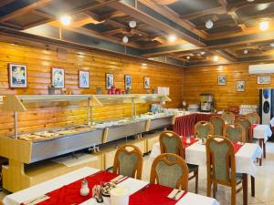 een restaurant met tafels en stoelen en houten wanden bij Majerik Hotel in Hévíz