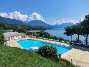 a large swimming pool with a view of a lake at leparadisachorges in Chorges