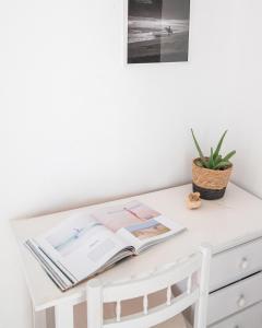a white desk with a book and a plant on it at Casa Harmonia in La Pared