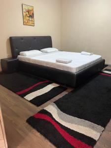 Bett in einem Zimmer mit einem schwarzen Bettrahmen in der Unterkunft Family White Hotel in Gnjilane
