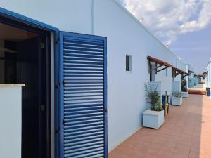 una porta blu del garage su un edificio bianco di Appartamento Dei Pini a Torre dell'Orso