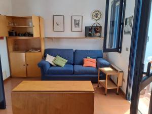 un soggiorno con divano blu e tavolo di Appartamento Dei Pini a Torre dell'Orso
