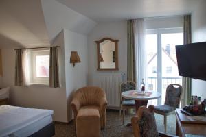 Habitación de hotel con cama, mesa y sillas en Hotel Quellenhof en Salzgitter