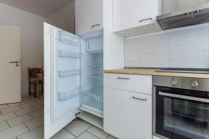 a kitchen with white cabinets and an empty refrigerator at 3 Zimmer FeWo Karli in Leipzig