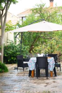 een tafel en stoelen met een parasol op een patio bij Casa di Betty in Càbras