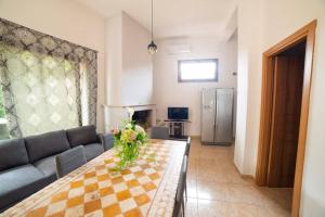 een woonkamer met een bank en een tafel met bloemen erop bij Casa di Betty in Càbras