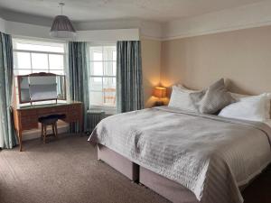 a bedroom with a bed and a desk and a mirror at Navigator Hotel in Bognor Regis