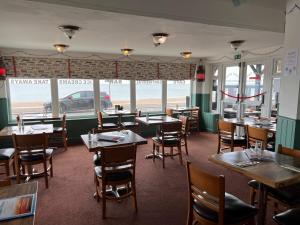 um restaurante com mesas e cadeiras e vista para o oceano em Navigator Hotel em Bognor Regis