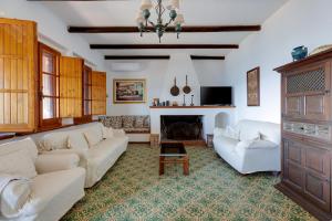 a living room with two white couches and a fireplace at Villa Timbora in Càbras