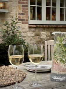 two glasses of white wine sitting on a wooden table at Plum Henley in Henley