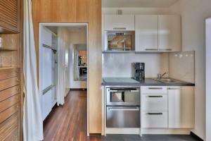 a kitchen with white cabinets and stainless steel appliances at Terrassenhaus, FeWo 76 in Duhnen