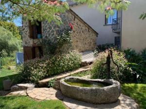 a garden with a stone bowl in front of a house at La Maison Rouziès in La Bastide-lʼÉvêque