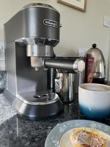 a mixer sitting on a counter next to a plate of food at The Old Coach House in Redlynch