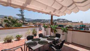 a table and chairs on a balcony with a view at Casa Lola Preciosa azotea vistas panorámicas in Almuñécar