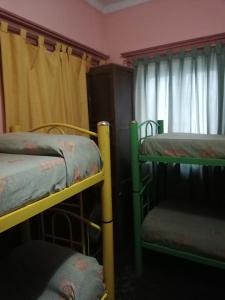 a room with three bunk beds and a window at Hostel Trotamundos in San Rafael