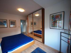 1 dormitorio con cama azul y espejo en AH1-004-Seeblick, en Scharbeutz