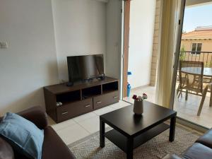 a living room with a tv and a coffee table at Pyla Palms A2 107 in Pyla
