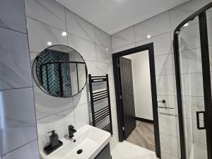 a bathroom with a sink and a mirror at Sun Inn - Boutique Apartments Bingley in Bradford