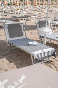 a bunch of chairs sitting on the beach at Hotel Capri 3 Stelle SUPERIOR in Lido di Jesolo