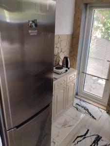 a stainless steel refrigerator in a kitchen with a window at Guesthouse Panorama in Mostar