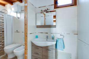 un baño con lavabo e inodoro en Villino Turchese, en Cabras 13 fotos más