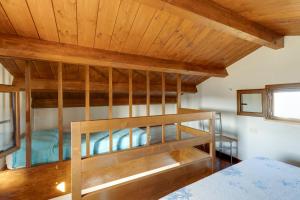 a bunk bed in a room with a wooden ceiling at Villino Turchese in Càbras