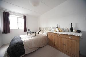 1 dormitorio con 1 cama con ordenador portátil en Stunning 1-Bed Apartment in Milton Keynes en Milton Keynes