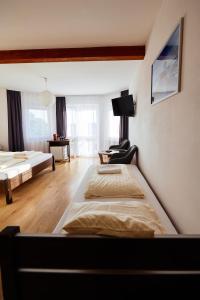 um quarto com duas camas e uma televisão na parede em VIPABO SolneSPA - Sauna, Grota Solna, Łaźnia parowa em Niechorze