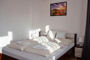 uma cama com cobertores brancos e almofadas em VIPABO SolneSPA - Sauna, Grota Solna, Łaźnia parowa em Niechorze
